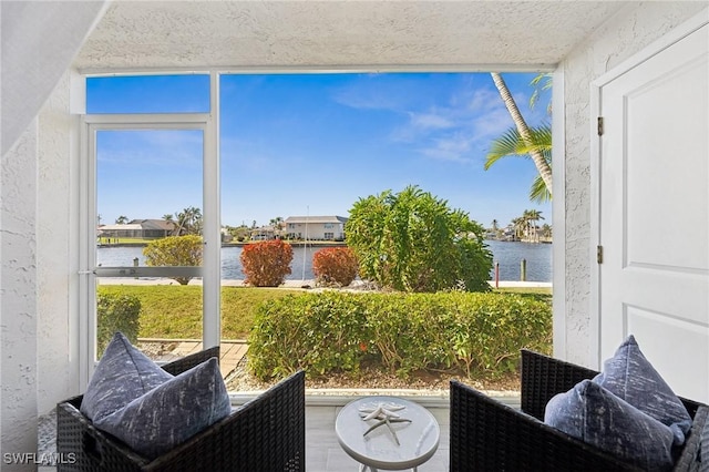 sunroom / solarium featuring a healthy amount of sunlight and a water view