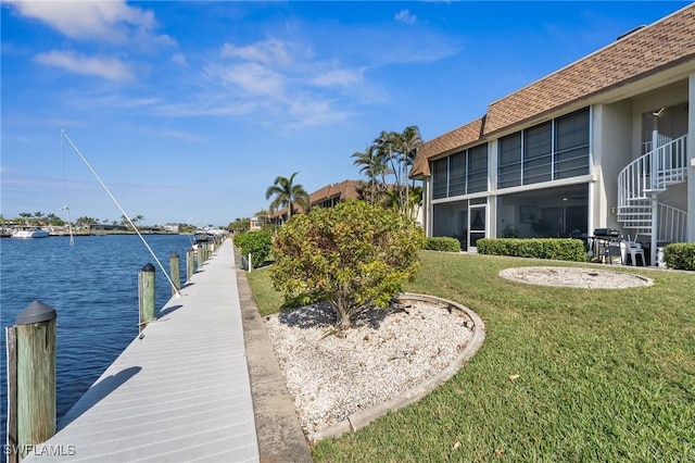 view of dock featuring a lawn and a water view