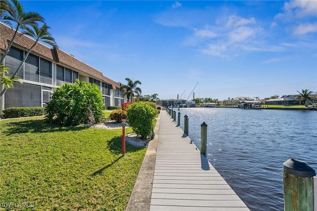 dock area with a yard and a water view