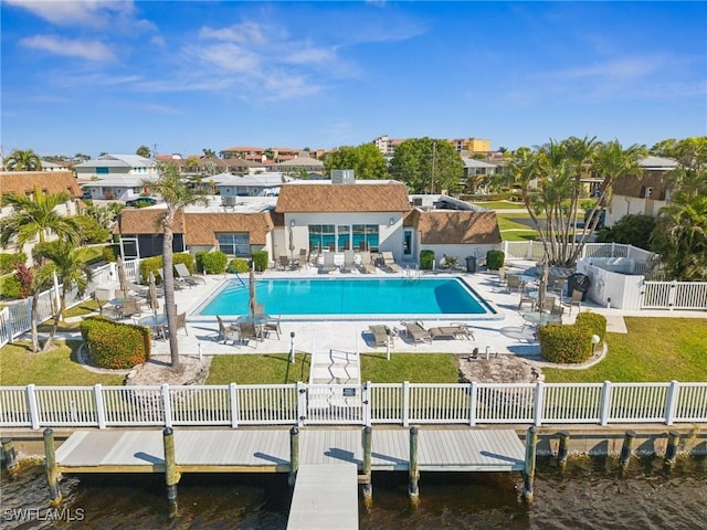 rear view of property featuring a lawn, a patio area, a water view, and a community pool