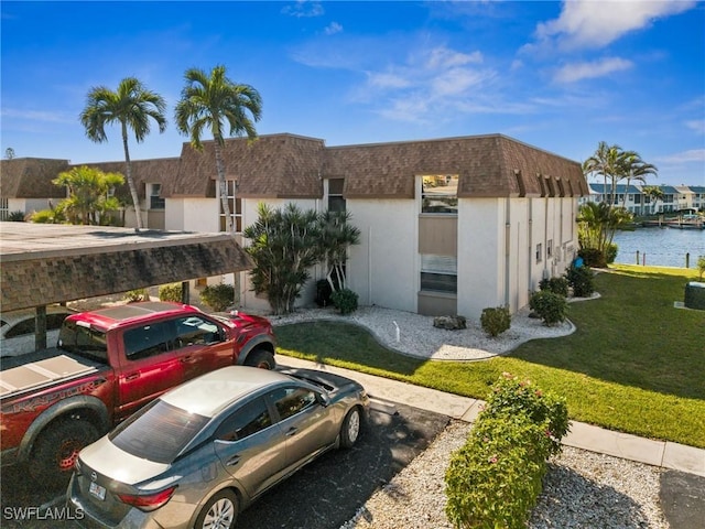 exterior space with a water view and a front lawn