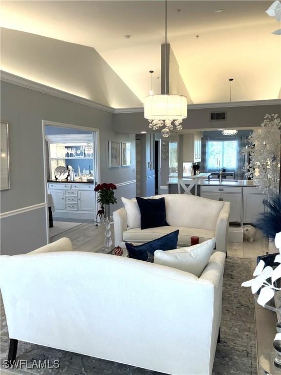 living room featuring wood-type flooring, an inviting chandelier, and vaulted ceiling