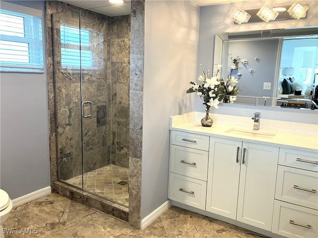 bathroom with marble finish floor, a shower stall, baseboards, and vanity