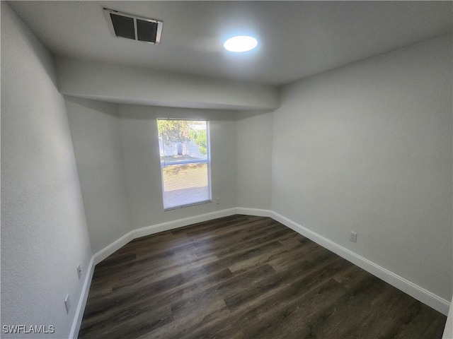 empty room with dark hardwood / wood-style flooring