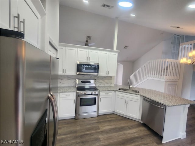 kitchen with kitchen peninsula, sink, white cabinets, and appliances with stainless steel finishes