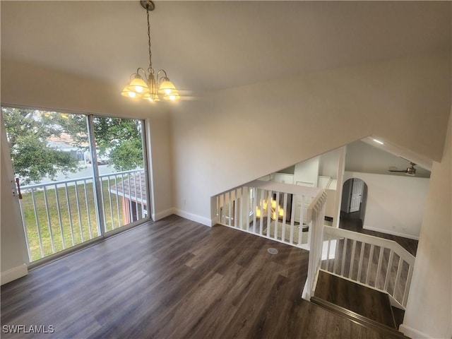 interior space with dark hardwood / wood-style flooring, vaulted ceiling, and a notable chandelier