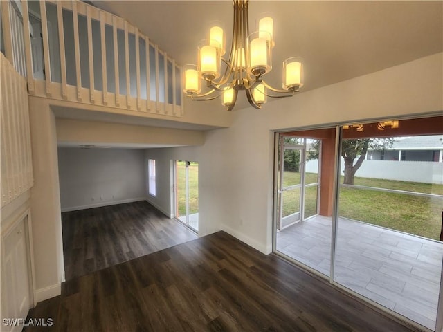 interior space featuring dark wood-type flooring and a notable chandelier