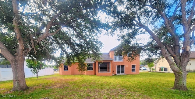 rear view of house featuring a lawn