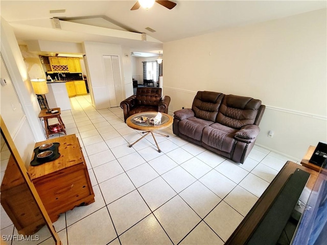 tiled living room with ceiling fan and lofted ceiling