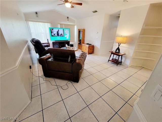 living room with ceiling fan, light tile patterned floors, and lofted ceiling