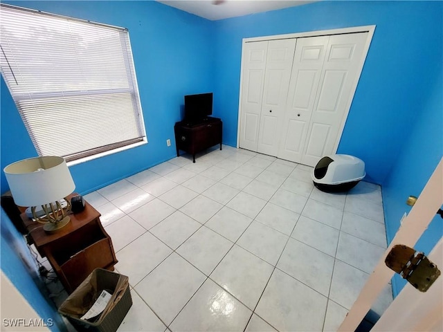 unfurnished bedroom featuring light tile patterned floors and a closet