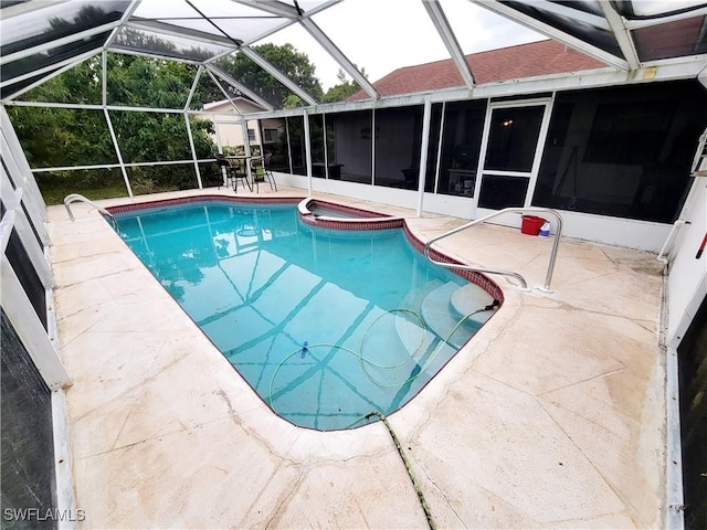 view of swimming pool with glass enclosure and a patio area