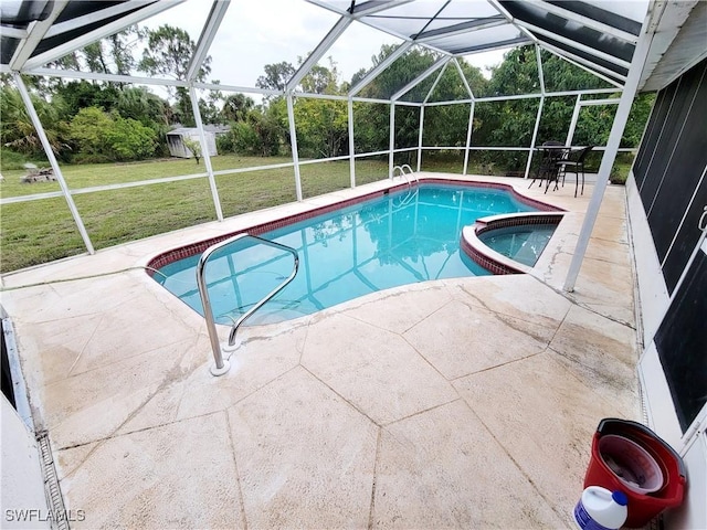 view of pool with glass enclosure, a shed, a yard, an in ground hot tub, and a patio