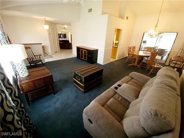 tiled living room with ceiling fan with notable chandelier and lofted ceiling