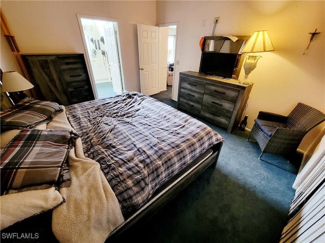 bedroom featuring dark colored carpet and connected bathroom