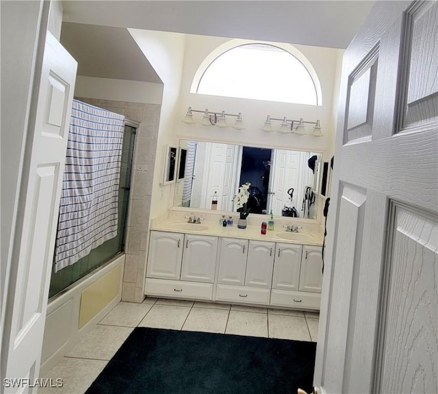 bathroom featuring tile patterned flooring, vanity, and enclosed tub / shower combo