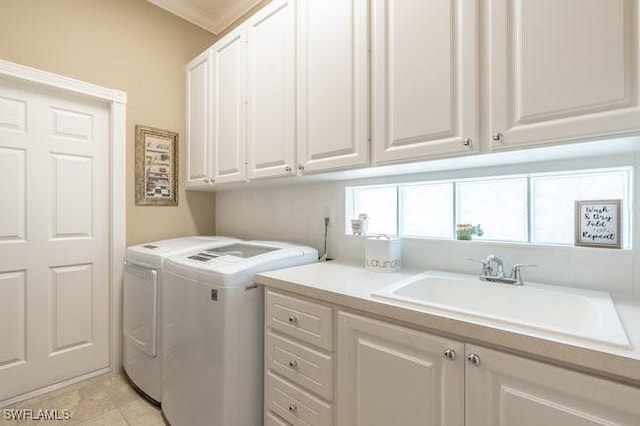 laundry room with washer and dryer, cabinets, sink, and crown molding