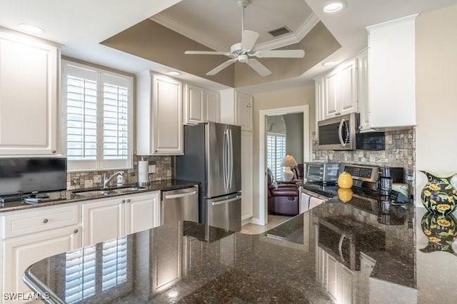 kitchen featuring white cabinets, a raised ceiling, sink, and appliances with stainless steel finishes