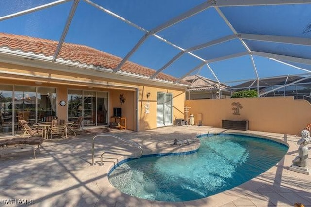 view of pool featuring glass enclosure and a patio