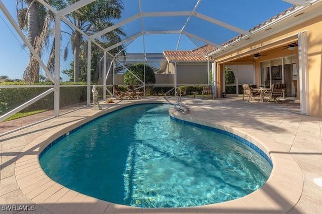 view of pool featuring a patio, ceiling fan, and a lanai