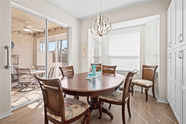 dining room featuring wood-type flooring and ceiling fan with notable chandelier