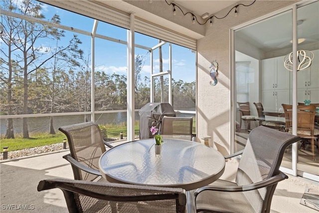 sunroom featuring a water view