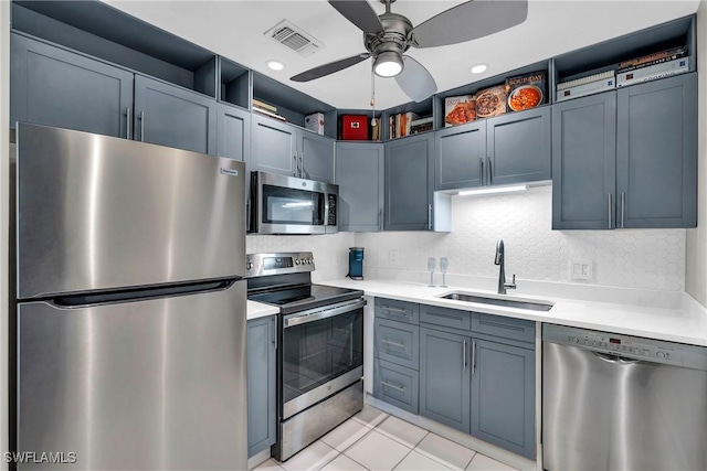 kitchen featuring sink, light tile patterned floors, appliances with stainless steel finishes, ceiling fan, and decorative backsplash