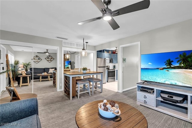 carpeted living room with ceiling fan