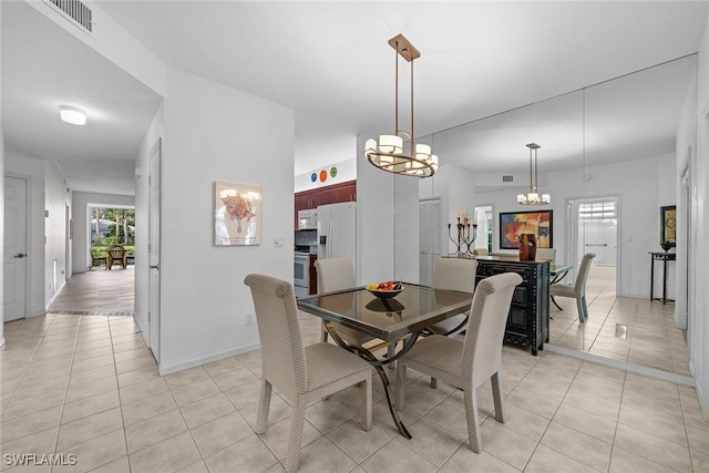 tiled dining space featuring an inviting chandelier