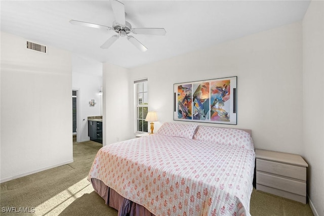 bedroom featuring ceiling fan, ensuite bathroom, and light colored carpet