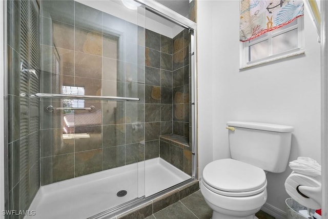 bathroom featuring toilet, tile patterned floors, and an enclosed shower