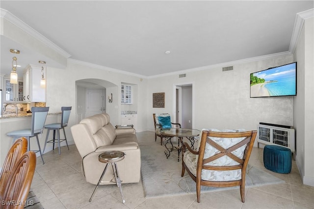 tiled living room featuring sink, crown molding, and heating unit