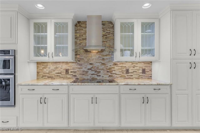 bar featuring white cabinetry, wall chimney range hood, light stone counters, decorative backsplash, and black electric stovetop