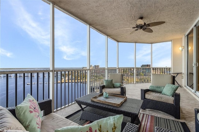 sunroom / solarium with ceiling fan, plenty of natural light, and a water view