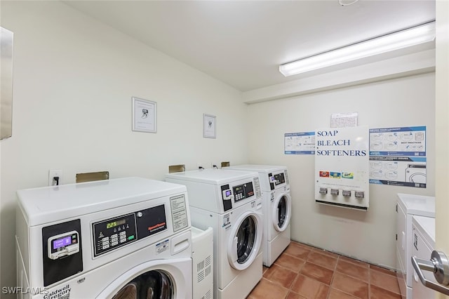 clothes washing area with light tile patterned flooring and washing machine and dryer