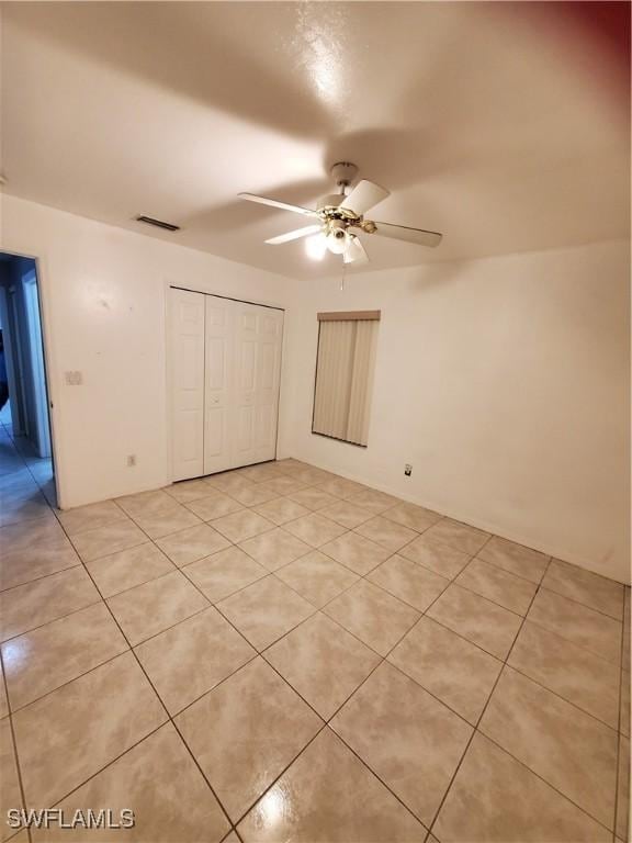 unfurnished bedroom with a closet, ceiling fan, and light tile patterned floors