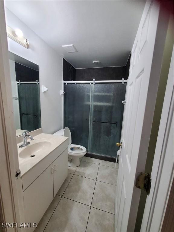 bathroom with toilet, tile patterned floors, walk in shower, and vanity