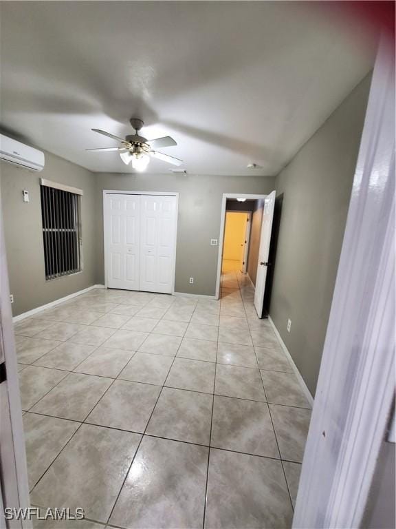 unfurnished bedroom with a wall mounted AC, ceiling fan, light tile patterned floors, and a closet