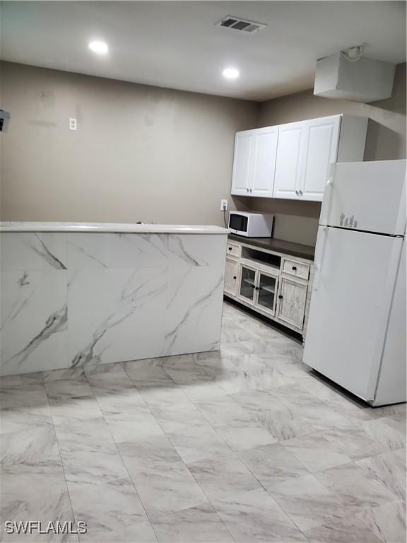 kitchen featuring white appliances and white cabinetry