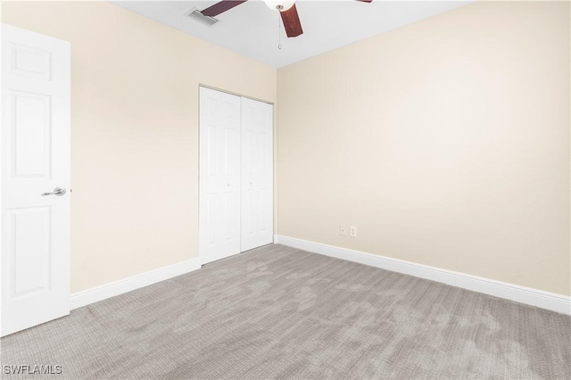 unfurnished bedroom with ceiling fan, a closet, and light colored carpet