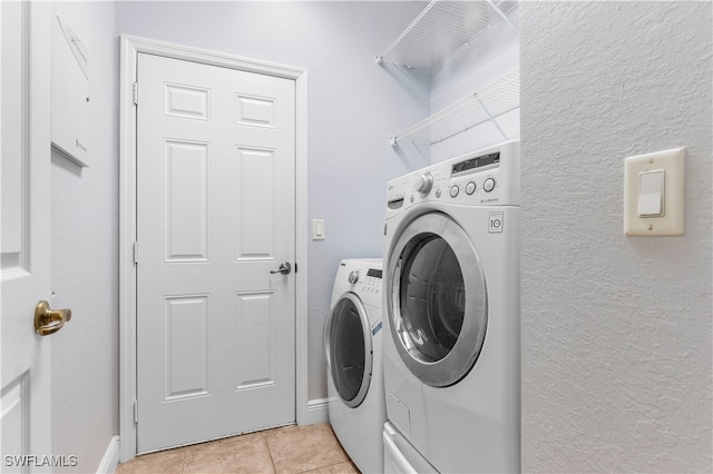 washroom featuring light tile patterned floors and washing machine and clothes dryer