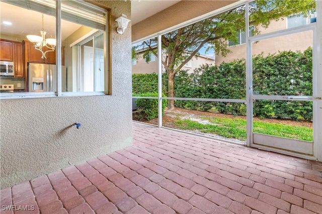 unfurnished sunroom with an inviting chandelier