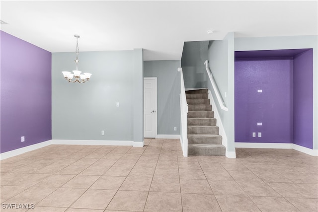 spare room with light tile patterned floors and an inviting chandelier