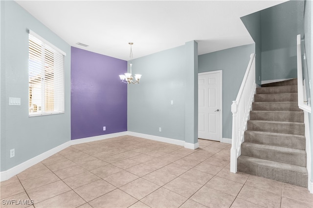 empty room featuring light tile patterned floors and an inviting chandelier