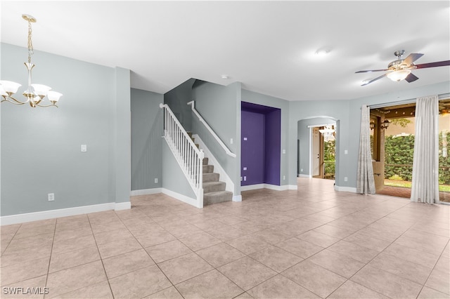 spare room featuring ceiling fan with notable chandelier and light tile patterned floors