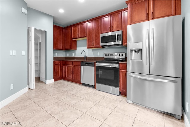 kitchen with appliances with stainless steel finishes, light tile patterned floors, and sink