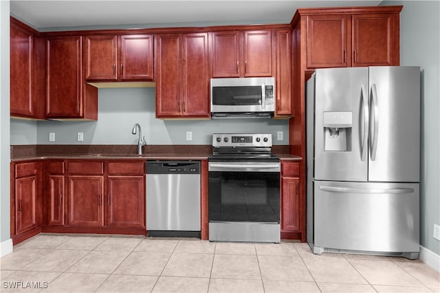 kitchen with sink, light tile patterned flooring, and stainless steel appliances