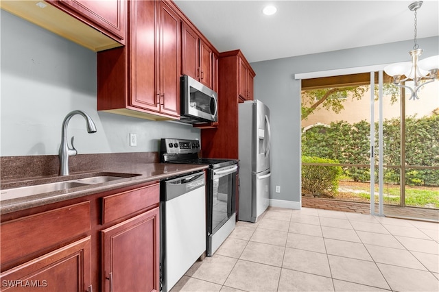 kitchen with an inviting chandelier, hanging light fixtures, sink, light tile patterned floors, and appliances with stainless steel finishes