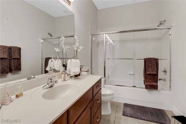 full bathroom featuring tile patterned flooring, vanity, toilet, and bath / shower combo with glass door