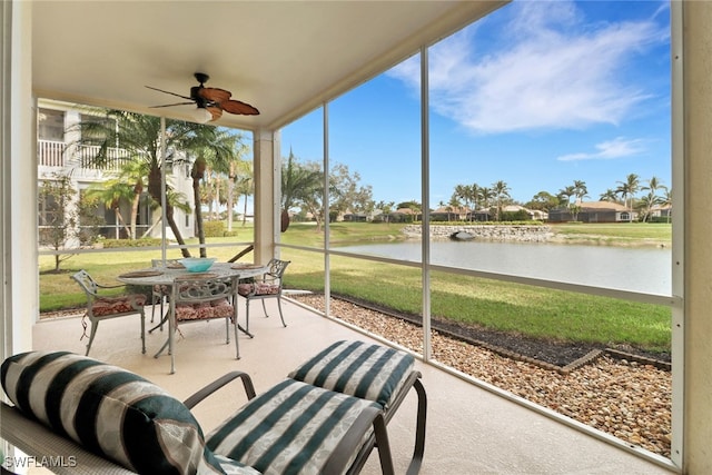 sunroom / solarium featuring ceiling fan, plenty of natural light, and a water view